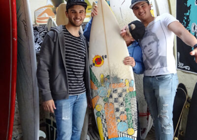 Photo des clients heureux à coté des planches de surf en location à notre hostel h2oholidays